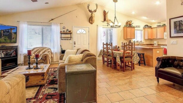 A spacious living room with a fireplace, a dining area, and a kitchen.