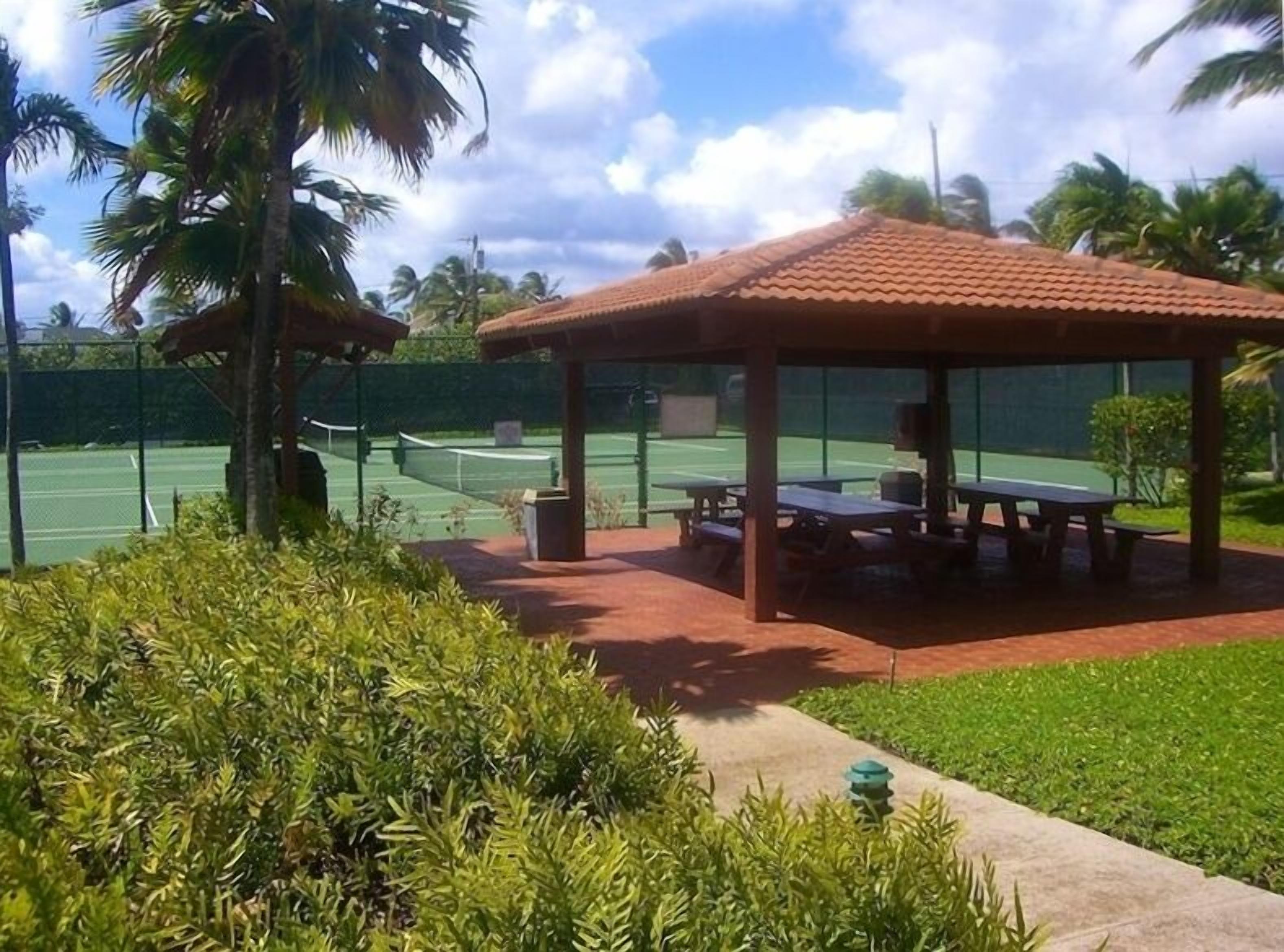 En tennisbane med et overdækket pavillon og siddeområde.