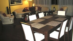 A hotel room with a dining area featuring a wooden table and chairs, a sofa set, a lamp, and a framed picture on the wall. - Right in the middle of the action Safe comfort  (Miraflores)