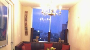 A cozy dining area with a round table, chairs, a chandelier, and a city view through a window. - Right in the middle of the action Safe comfort  (Miraflores)