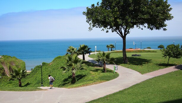 A pathway leading to a grassy area with a view of the ocean. - Right in the middle of the action Safe comfort  (Miraflores)