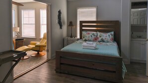 Une chambre à coucher avec un lit en bois, une chaise, une lampe et une armoire.