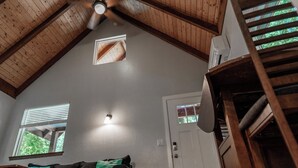 A room with a sloped ceiling, a ceiling fan, a window with blinds, a door, and a built-in shelf. - Newly built deluxe cabins, in a private redwood setting near the Smith River (Hiouchi)