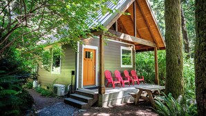 A small cabin with a porch, surrounded by trees. - Newly built deluxe cabins, in a private redwood setting near the Smith River (Hiouchi)