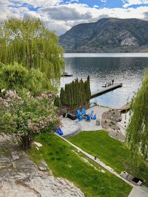 Patio affacciato sul lago con posti a sedere all'aperto, un molo e vista sulle montagne.