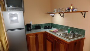 A compact kitchen with a refrigerator, a coffee maker, a microwave, and a sink. - Wish Willy Getaway Cabana  (Santa Elena)