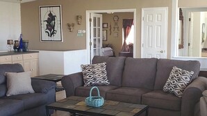 A living room with a sofa, coffee table, and a ceiling fan. - 5 Minutes From The Lake! Million Dollar Views! (Page)