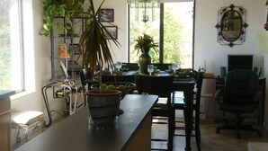 A kitchen with a central island, bar stools, a dining table, and a TV. There are potted plants and a chandelier. - 5 Minutes From The Lake! Million Dollar Views! (Page)