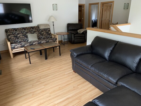 A living room with a sofa, a coffee table, a TV, and a lamp.