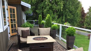 A deck with outdoor furniture, a fire pit, and potted plants. - Beautiful Lake Whatcom/Sudden Valley House Rental steps from the water (Bellingham)