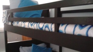 Een stapelbed met een bedovertrek en kussens met een patroon.