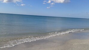 Una playa con agua cristalina y una orilla arenosa.
