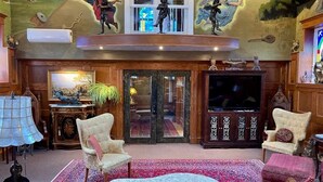 A living room with a large window, a fireplace, and a television. - Amazing Unique Church for rent  - St. Cecilia by the Sea (Purcells Cove)