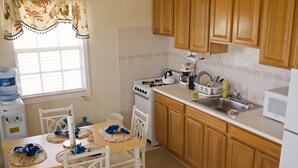 A kitchen with wooden cabinets, a stove, a microwave, and a sink.