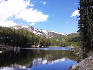 Escape to a serene lakeside haven with breathtaking views of snow-capped mountains and dense forests.