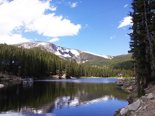 A serene lake surrounded by dense forests and snow-capped mountains. - Colorado Mountain Retreat - Spacious Cabin with Hot tub (Idaho Springs)