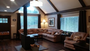 Relax in the spacious living room with a large sofa, stove, and floor lamp.
