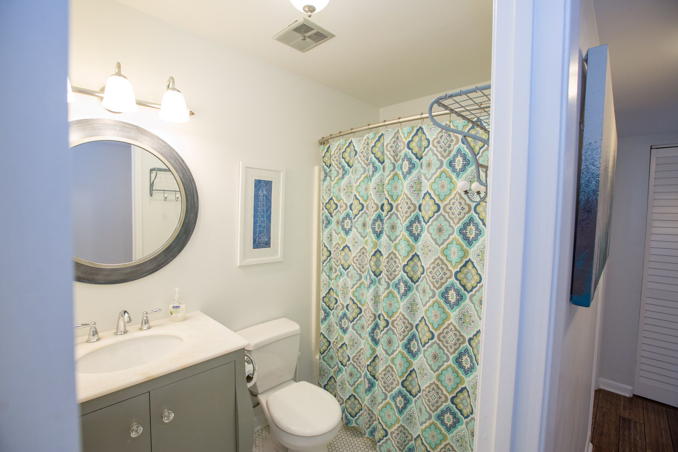 A bathroom with a toilet, sink, and shower curtain.