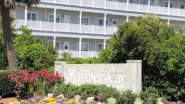 Een meerhoog gebouw met een bord waarop 'Mariners Cay' staat.