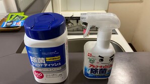 Eine Küchenarbeitsplatte mit einem blauen Behälter und einer Sprühflasche.