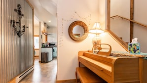 Een gezellige kamer met een houten piano, een spiegel en een lamp.