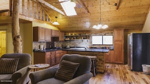 Una cocina amplia con armarios de madera, una isla grande y un refrigerador.