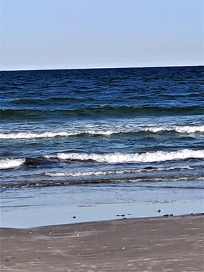 A beach with waves and a clear sky. - Fish from the pier, swim in the pool, walk to the beach. (Corpus Christi)