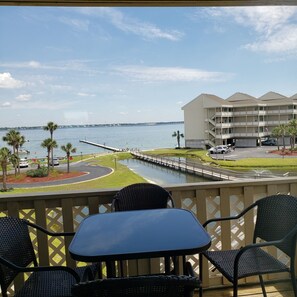 Ein Balkon mit Blick auf einen Yachthafen, ein Wasserweg und ein Hotelgebäude.