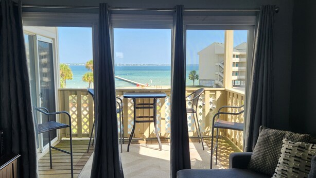Ein Balkon mit Meerblick, einem Tisch und zwei Stühlen.