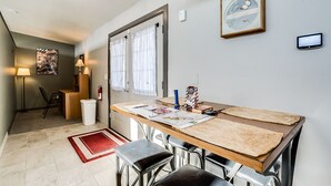 Uma cozinha compacta com uma mesa de madeira, banquetas e um tapete vermelho.