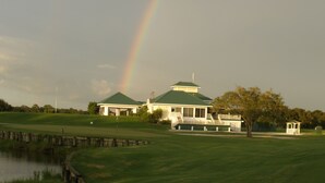 A golf course with a house and a gazebo.