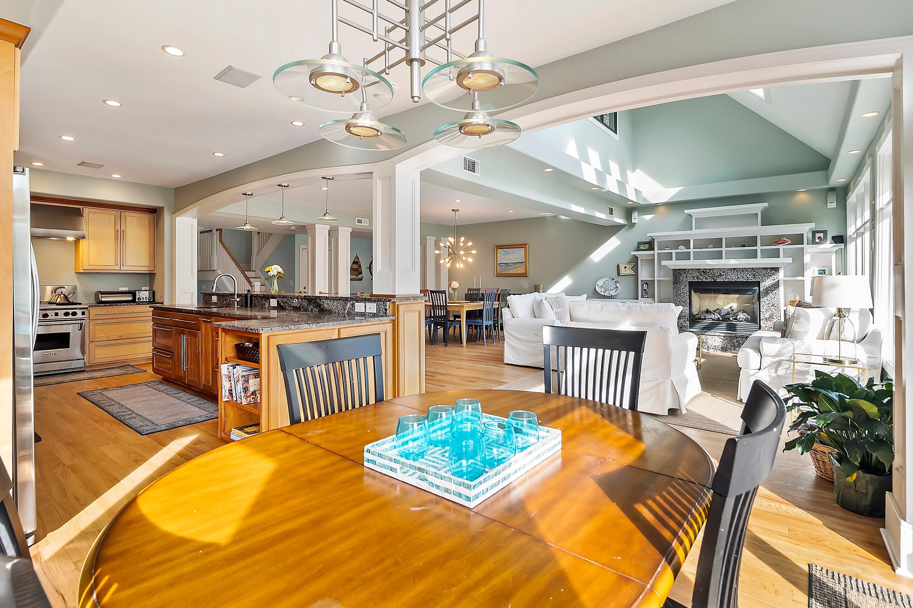 A spacious living area with a dining table, kitchen, and a fireplace.