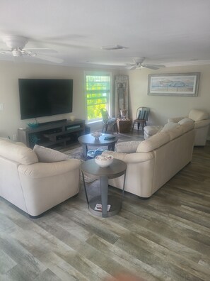 Relax in this stylish living room with a large flat-screen TV, comfortable sofa, and a small coffee table.