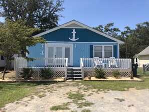 A small, single-story building with a blue exterior and white porch.