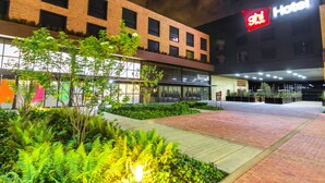 Un hotel con fachada de ladrillo moderno, un acceso bien iluminado y un letrero que indica que es un Hotel GHL.