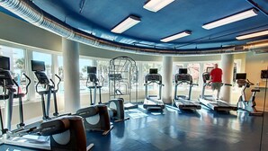 Ein Fitnessraum mit Laufbändern, Crosstrainern und Rudergeräten.
