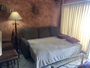 A room with a bed, a chair, a lamp, and a wall decoration. - Ground Level, On The Beach In Front of 4 surf breaks (San Jose del Cabo)