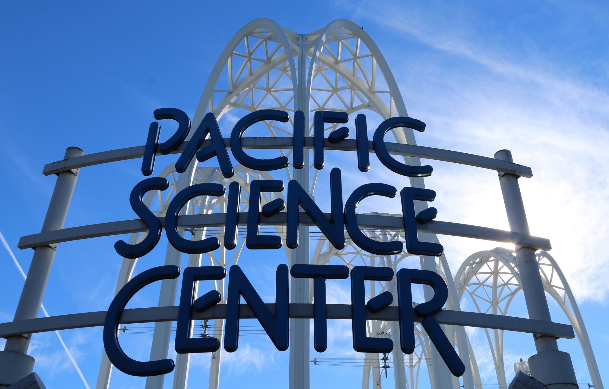 A sign with the words "PACIFIC SCIENCE CENTER" against a clear blue sky.