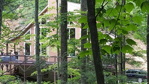 Un bâtiment doté d’une terrasse en bois et d’un escalier menant à un deuxième étage.