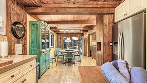 Una cocina rústica con vigas de madera, una isla central y un refrigerador.
