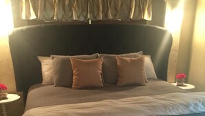 A neatly made bed with a dark headboard, multiple pillows, and a white comforter. - Sanders Island View Beach Home only 3 blocks to the beach!  (Kingston)