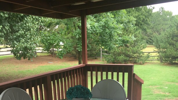 A covered patio with a round glass table and white chairs. - Sanders Island View Beach Home only 3 blocks to the beach!  (Kingston)