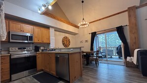 A modern kitchen with wooden cabinets, stainless steel appliances, and a large window with a view of the outdoors. - ⛳️110 Golf Resort, 3 Bed 3 Bath, Sleeps 12, central A/C & private hot tub⛳️ (Kimberley)