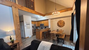 A modern kitchen with wooden cabinets, a large island, and a dining area with a wooden table and chairs. - ⛳️110 Golf Resort, 3 Bed 3 Bath, Sleeps 12, central A/C & private hot tub⛳️ (Kimberley)