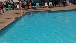 A swimming pool with clear blue water, surrounded by lounge chairs and umbrellas. - Waterfront Condo located on the shores of Lake Erie in Port Clinton, Ohio. (Port Clinton)