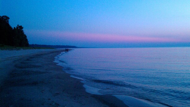 En strand med et roligt hav og en klar himmel.