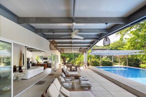 A covered outdoor area with a pool, seating, and a kitchen area. - Outdoor Living in Absolute Privacy Steps from the Water's Edge (Playa Grande)