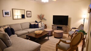 A living room with a large sofa, a coffee table, a TV, and a chair. - Your search ends here! (Newport)