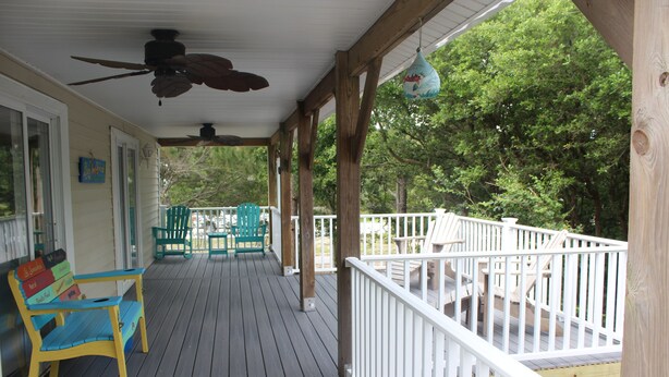 A covered porch with a wooden deck, a ceiling fan, and a hanging decorative item. - 4 Bedroom, 2.5 Bath,  sleeps 8,  Ocean View, Large Family Room and Sunroom (Emerald Isle)