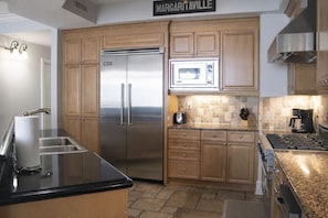 A kitchen with wooden cabinets, stainless steel appliances, a microwave, and a gas stove.